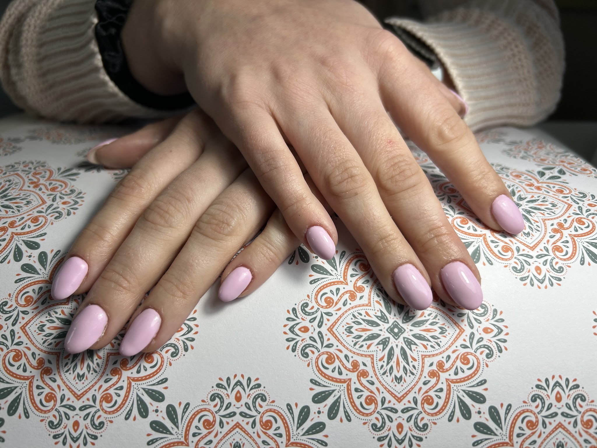 Lila amandelvormige nagels op een mat met een ornamentpatroon