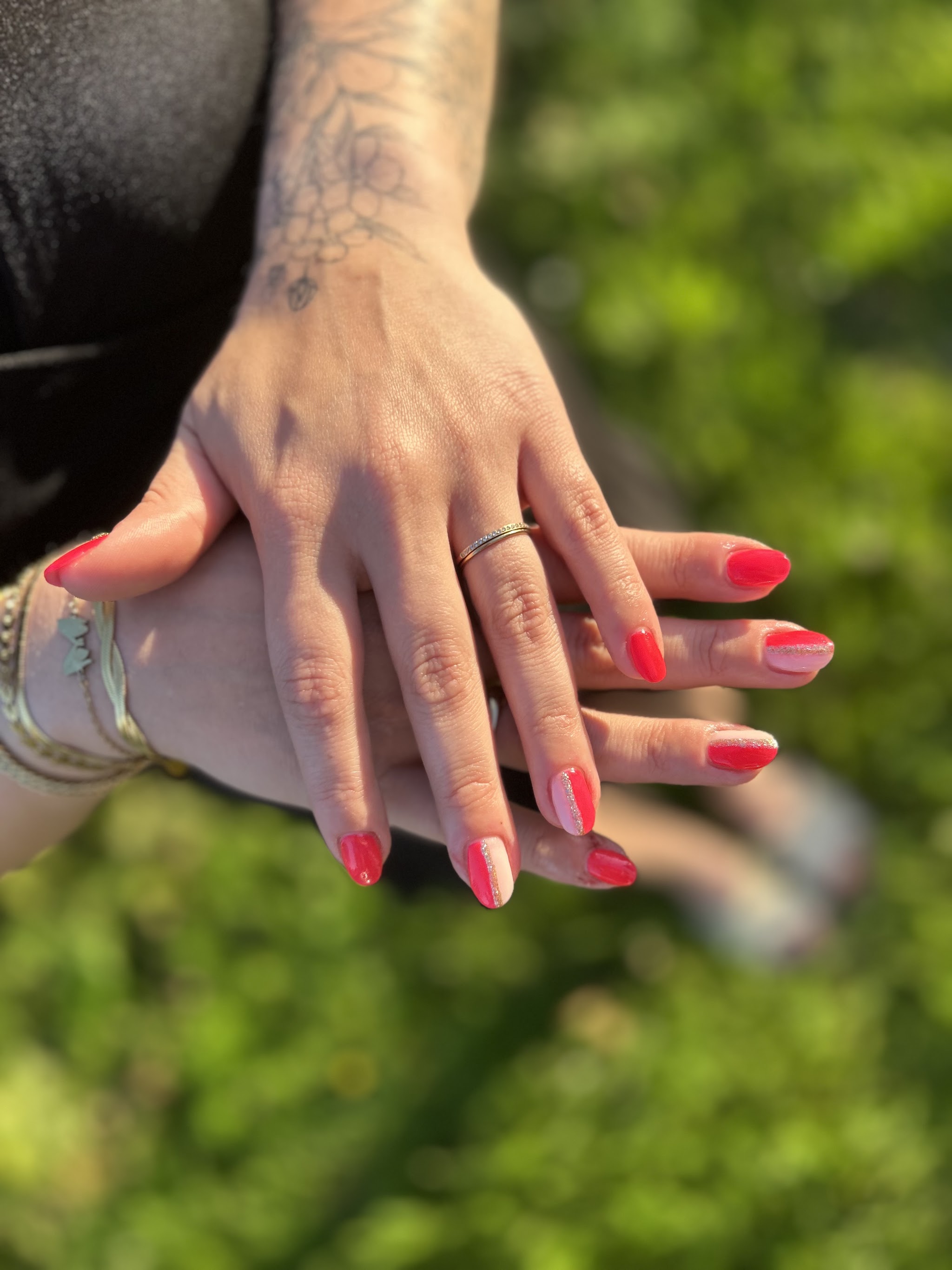 Rode nagels, twee handen buiten in het gras